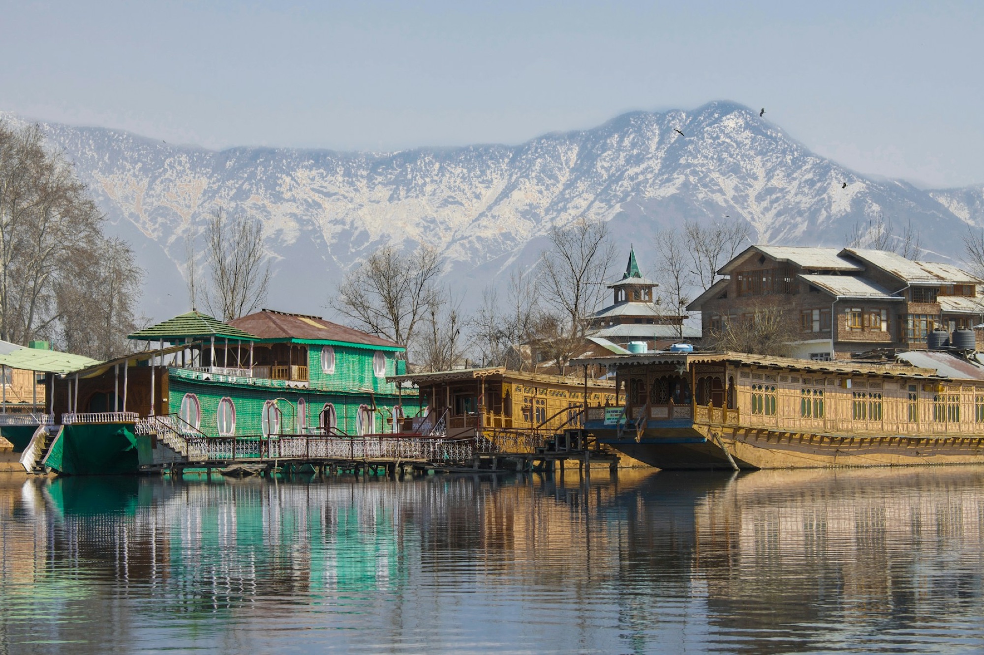 Traditional houseboats on a tranquil lake in Kashmir