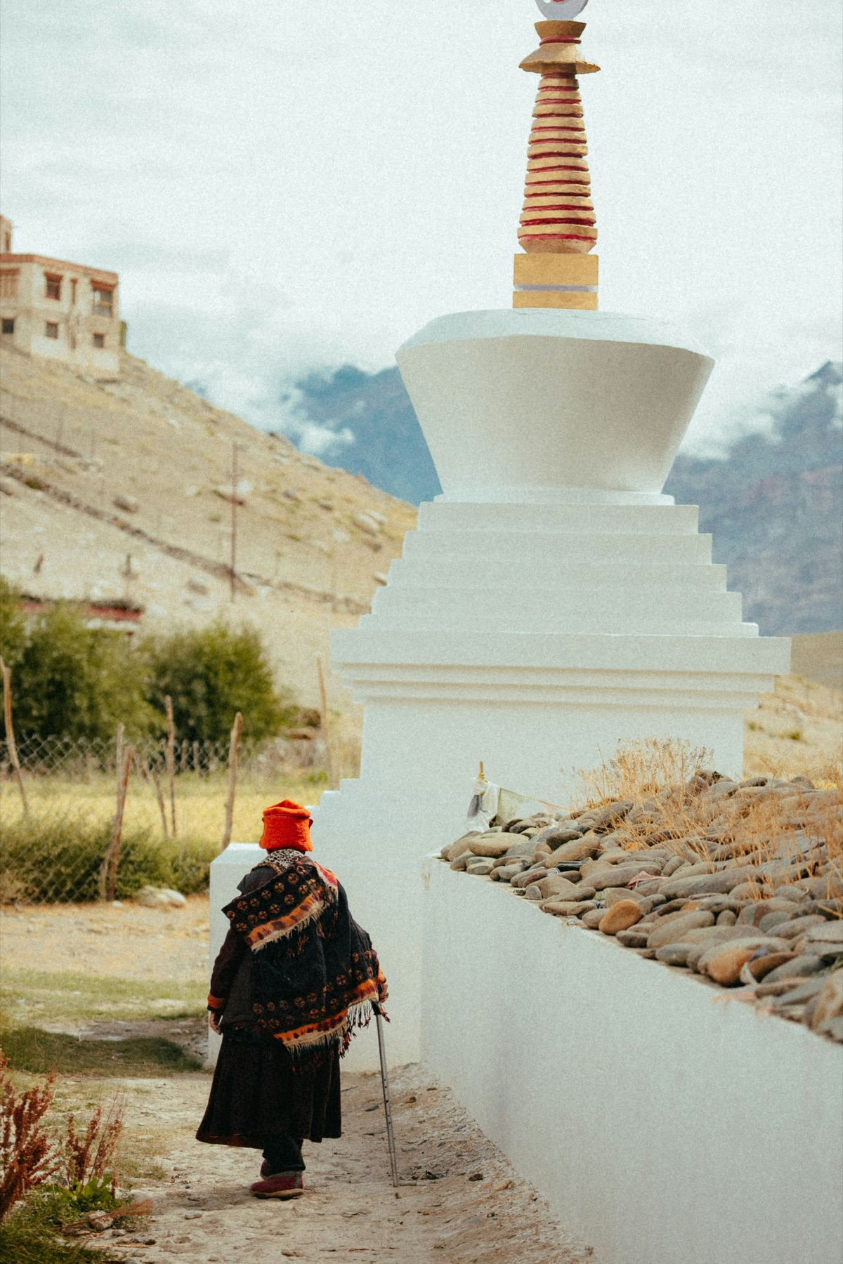A local woman walking beside a Ladakhi stupa